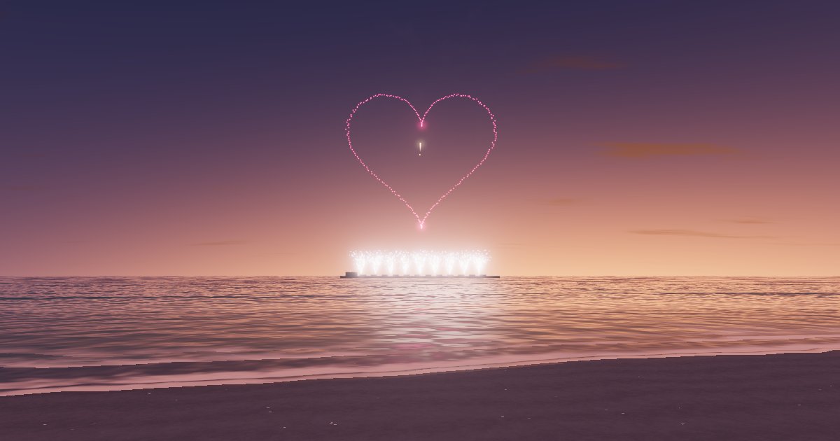 A heart drawn in pink firework sparks above a calm sea at sunset